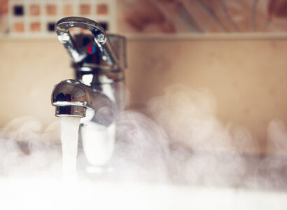 Hot water coming out of a tap, causing steam