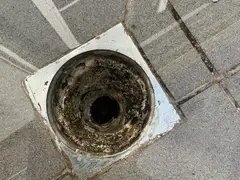 Balcony floor drain choked with concrete slurry in Como