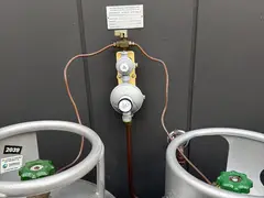 LPG gas bottles and regulator beside a Como granny flat