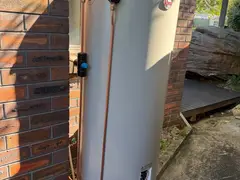 New Rheem electric hot water system beside a brick wall in Engadine