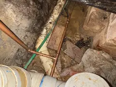 Water and waste pipes under a house in Kareela