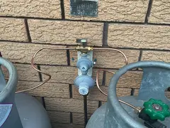 New LPG regulator fitted between two gas bottles at a Kirrawee home
