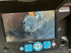 Tree roots inside a sewer pipe on a drain camera screen in Loftus